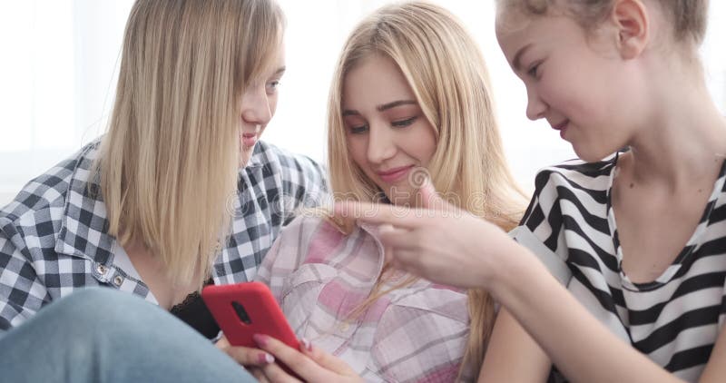 Teenage girls browsing social media content on mobile phone
