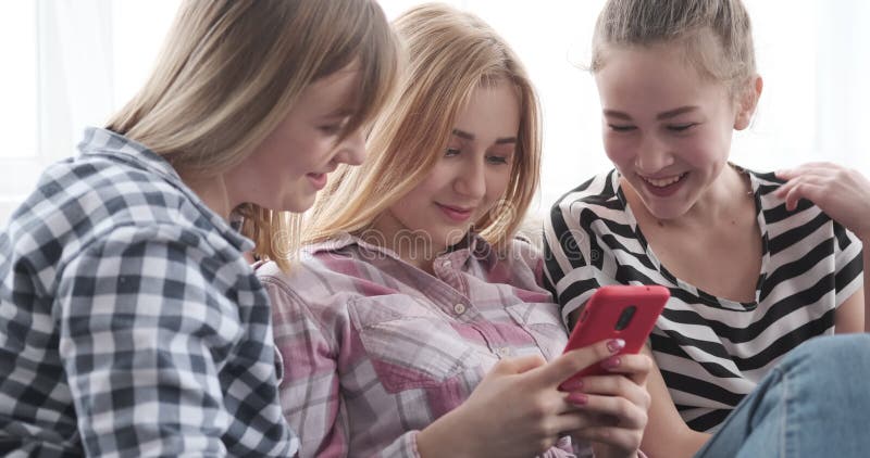 Teenage girls browsing social media content on smartphone