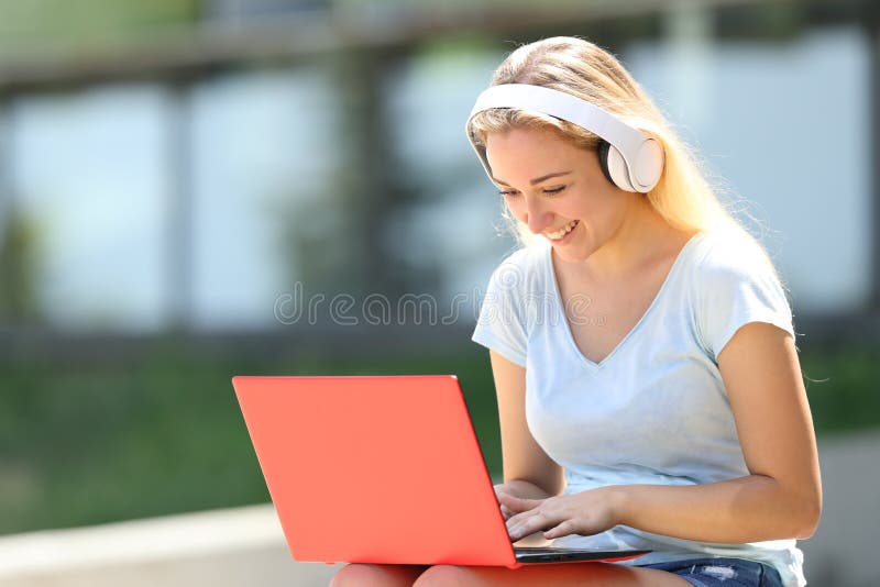 Happy teenage student e-learning using laptop and headphones stock photography Happy teenage student e-learning using laptop and headphones stock photography