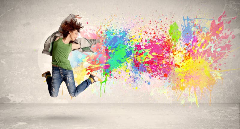 Happy teenager jumping with colorful ink splatter on urban background