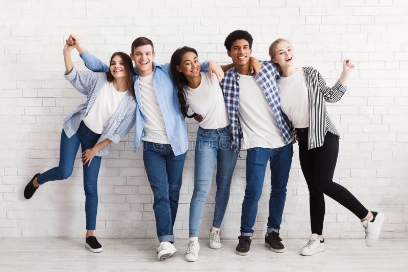 Happy teenagers having fun and posing over white wall