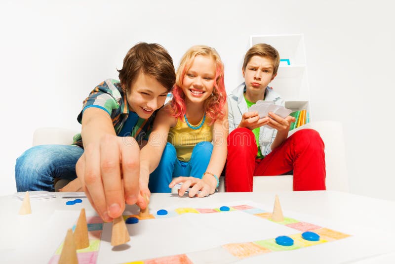 Happy teenagers play table game together at home