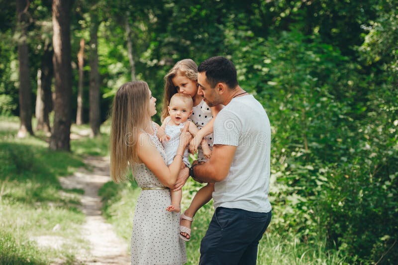 Happy Tenderfamilie Große Schwester küsst ihre kleine Schwester im Freien auf die Stirn lizenzfreie stockbilder Happy Tenderfamilie Große Schwester küsst ihre kleine Schwester im Freien auf die Stirn lizenzfreie stockbilder
