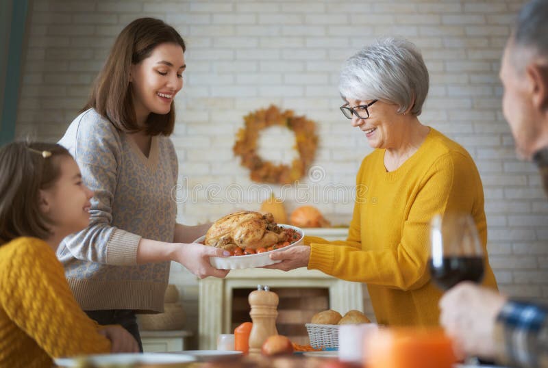 Happy Thanksgiving Day! Autumn feast. Family sitting at the table and celebrating holiday. Grandparents, mother and child. Traditional dinner