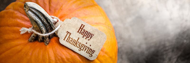 Pumpkin with Happy Thanksgiving tag. Black background. Pumpkin with Happy Thanksgiving tag. Black background.