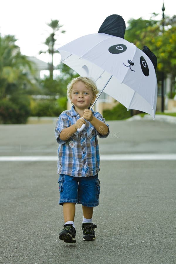 Bambino tenendo il suo ombrello in un giorno di pioggia.