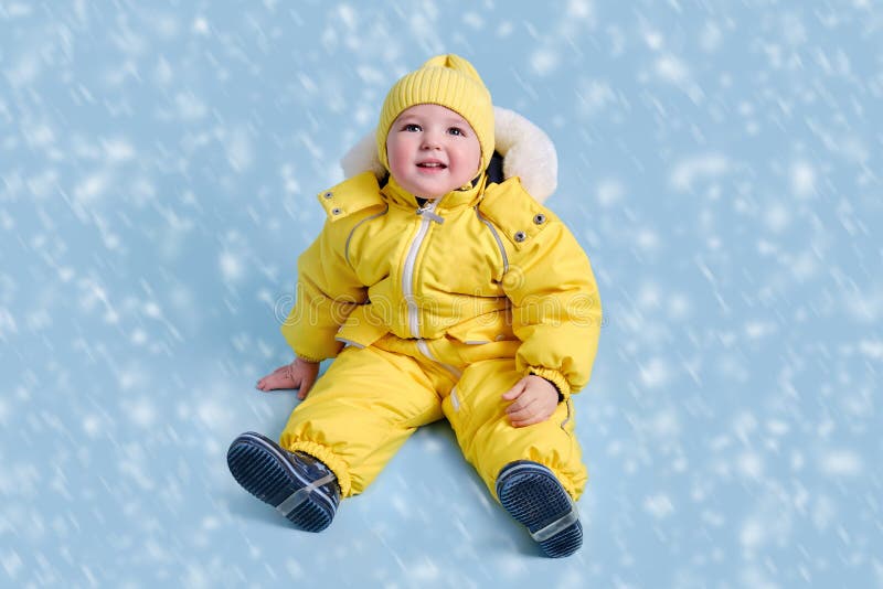 Happy Toddler Baby in Winter Clothes Snowsuit Kisu on Studio Blue Bac ...