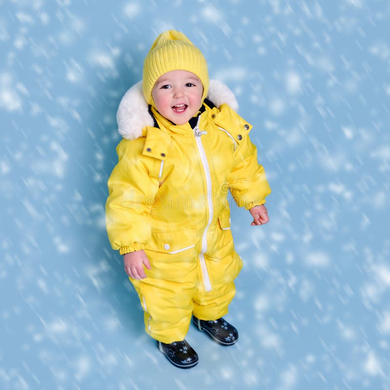 Happy Toddler Baby in Winter Clothes Snowsuit Kisu on Studio Blue Bac ...