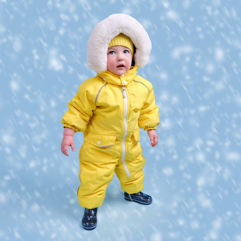 Happy Toddler Baby in Winter Clothes Snowsuit Kisu on Studio Blue Bac ...