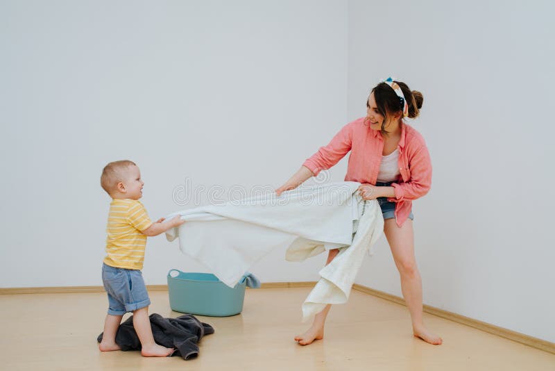 Happy toddler son and his mother are playing tug of war with towel stock photography Happy toddler son and his mother are playing tug of war with towel stock photography