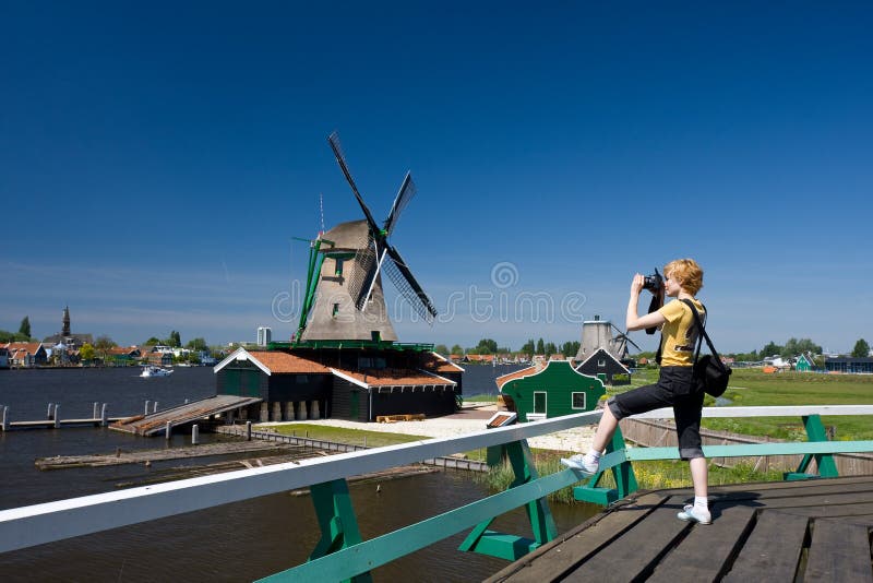 Happy tourist with photo camera and Dutch mill on royalty free stock photos