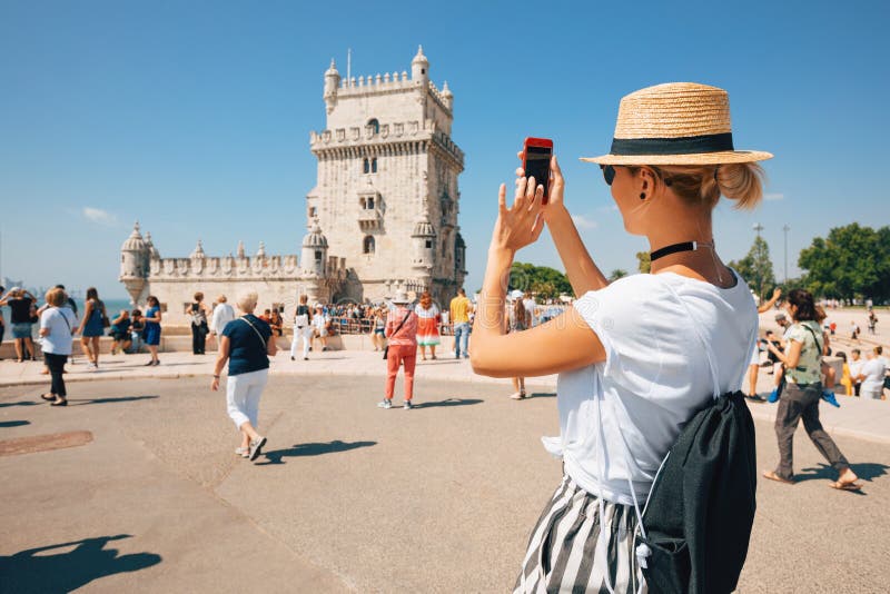Happy traveler girl in Lisbon near Belem Tower. Tourist woman taking picture of Belem Tower, Portugal royalty free stock images Happy traveler girl in Lisbon near Belem Tower. Tourist woman taking picture of Belem Tower, Portugal royalty free stock images