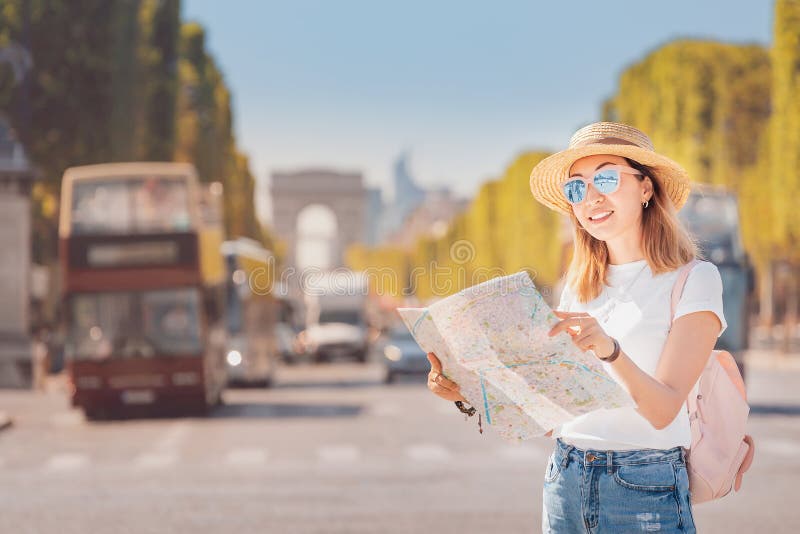 Traveler girl reading map in the background of the traffic on Avenue Champs elysées. Tourism and students in France and royalty free stock image Traveler girl reading map in the background of the traffic on Avenue Champs elysées. Tourism and students in France and royalty free stock image