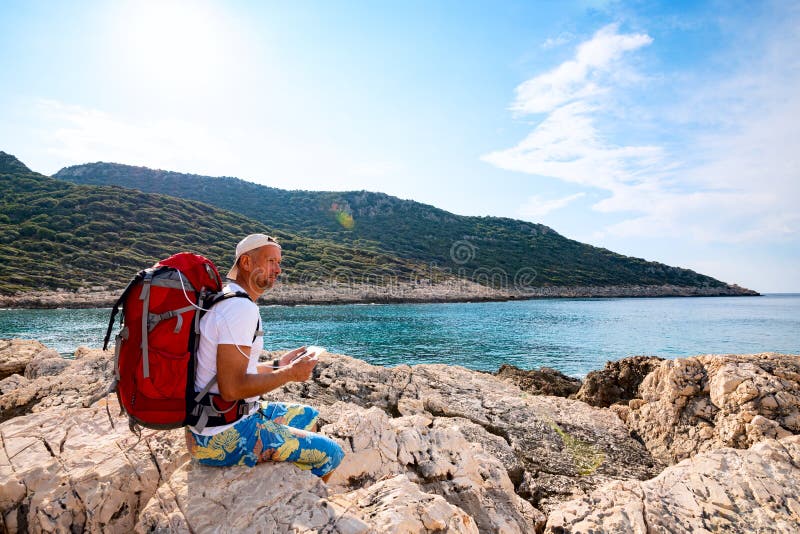 Happy traveler with a portable solar battery attached to his backpack royalty free stock photo Happy traveler with a portable solar battery attached to his backpack royalty free stock photo