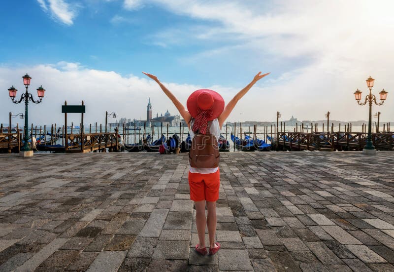 A happy woman stands in front of the gondolas of the empty St. Mark`s Square in Venice, Italy royalty free stock photos A happy woman stands in front of the gondolas of the empty St. Mark`s Square in Venice, Italy royalty free stock photos