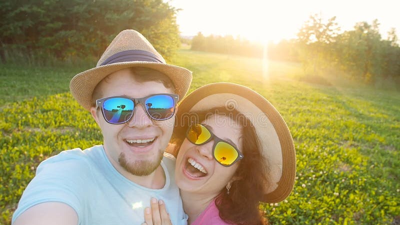 Happy traveling couple making selfie sunny summer colors at sunset