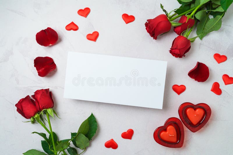 Happy Valentine`s day concept with greeting card mockup, heart shape candle and rose flowers on bright background. Top view, flat