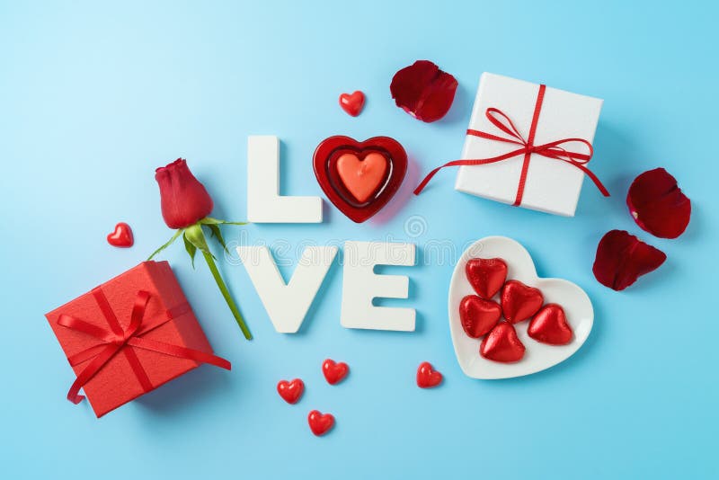 Happy Valentine`s day creative background with love letter, heart shape candle and gift boxes. Top view, flat lay