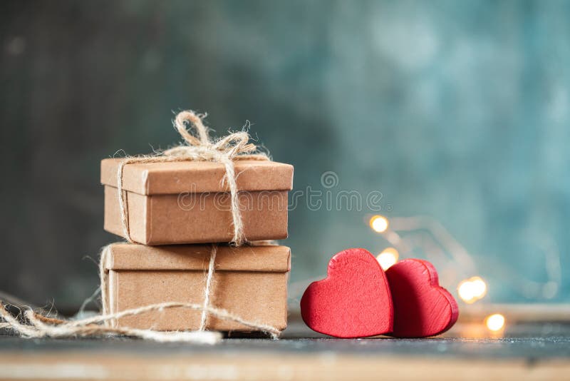 Happy Valentine`s Day. Eco friendly packaging of the gift and present. Cardboard box tied with rope with red hearts on the dark