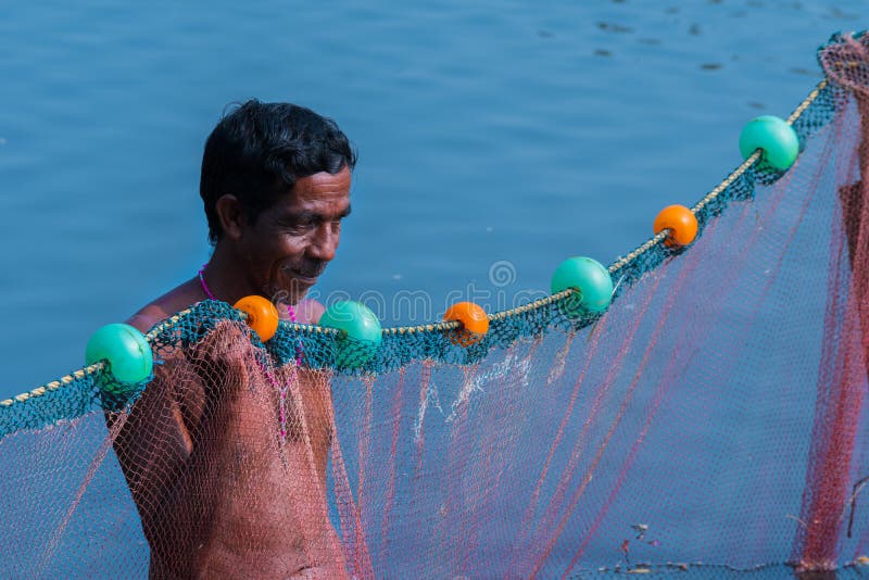 A Village Fisherman is Throwing a Net for Fishing in a Pond