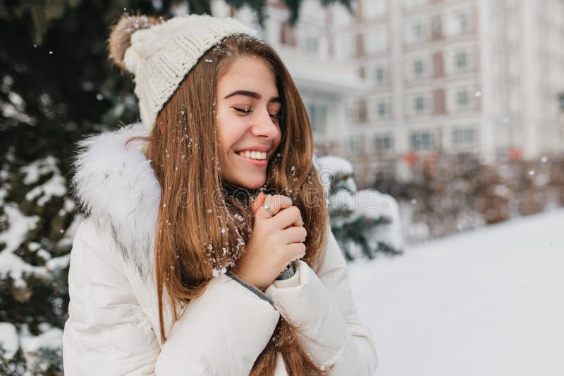 Happy winter time of young joyful woman enjoying snow in city. Attractive girl, long brunette hair, smiling with closed stock images Happy winter time of young joyful woman enjoying snow in city. Attractive girl, long brunette hair, smiling with closed stock images