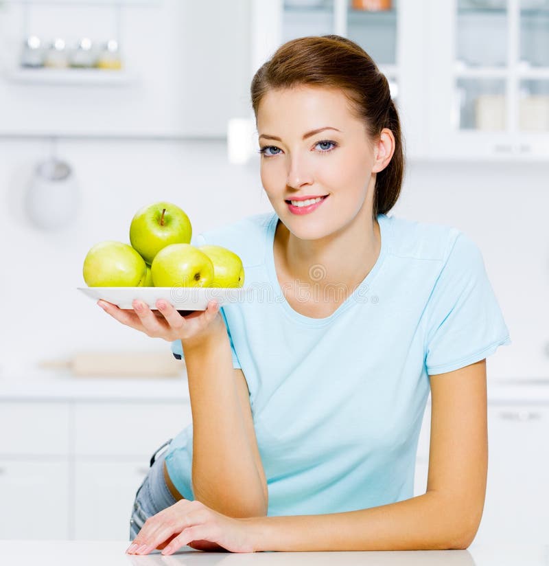 Happy woman with apples on a plate