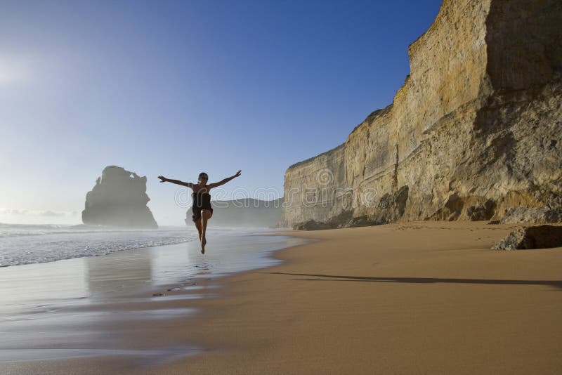 Šťastná žena, skákanie na pláži.