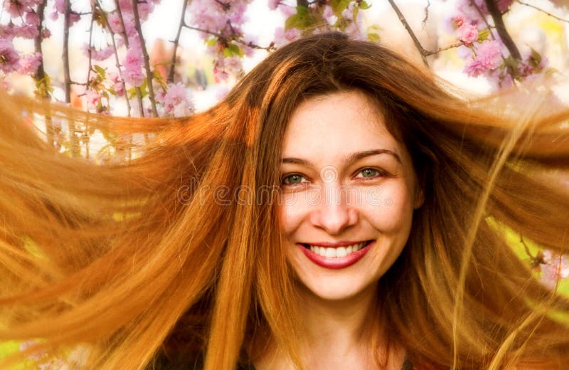 Happy woman with beautiful long hair and flowers