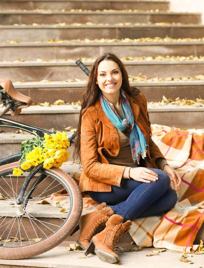 Happy woman with bike in autumn park