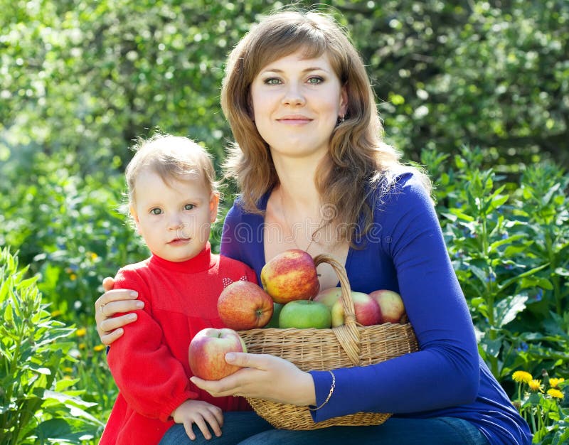 Happy woman and child apples in garden