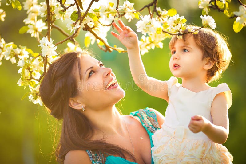 Glückliche Frauen und Kinder, die in der blühenden Frühlingsgarten.