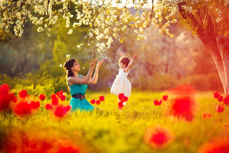 Glückliche Frauen und Kinder, die in der blühenden Frühlingsgarten.