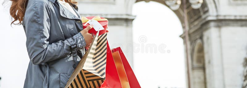 Happy woman with Christmas present near Arc de Triomphe in Paris