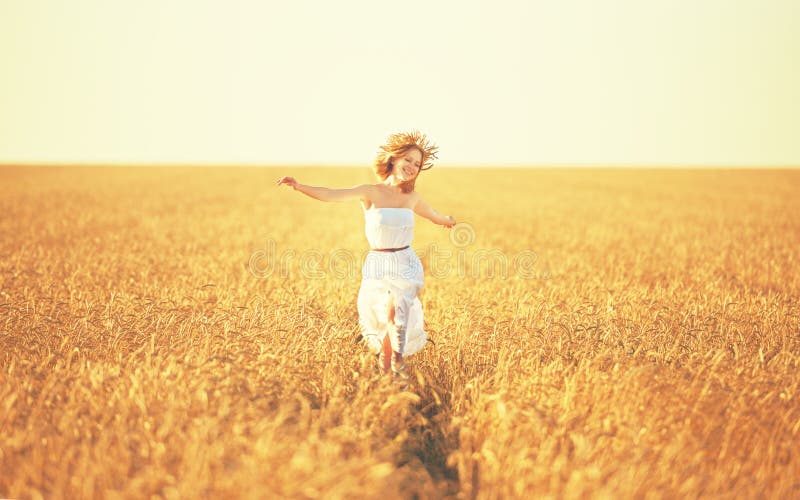 Happy woman enjoying life in golden wheat field stock image