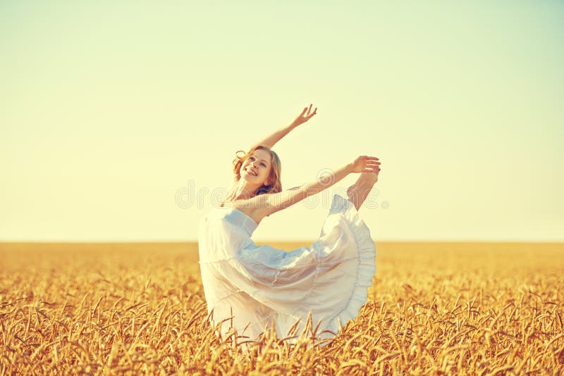 Happy woman enjoying life in golden wheat field royalty free stock photo