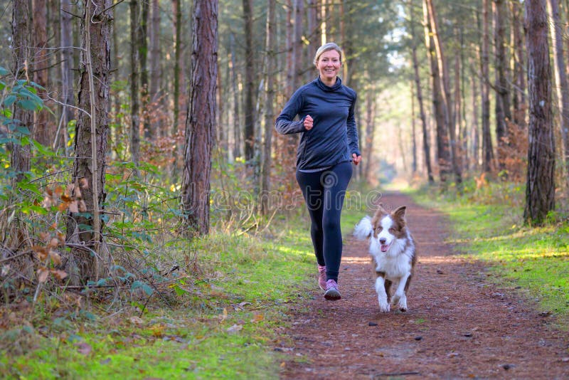 Happy woman full of vitality exercising her dog