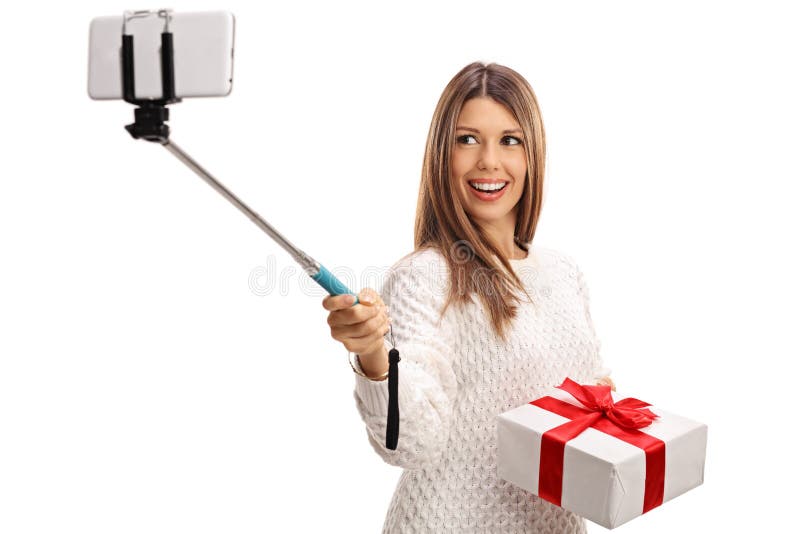Happy woman holding present and taking selfie with a stick royalty free stock photography