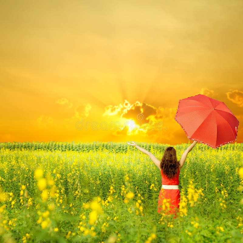 Happy woman holding red umbrella and sunset