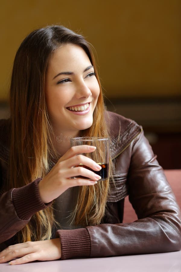 Happy woman holding a refreshment in a restaurant