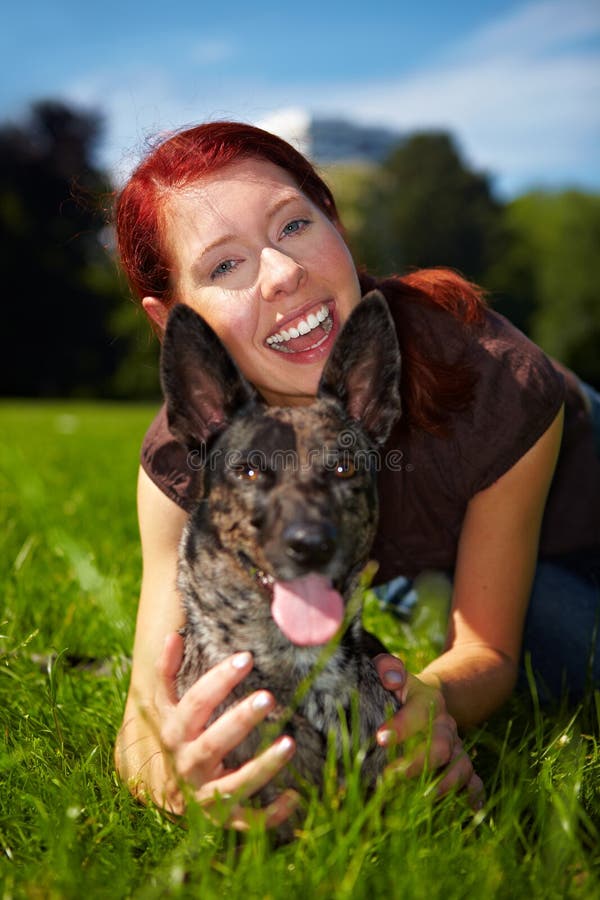Happy woman holds dog in park stock photo