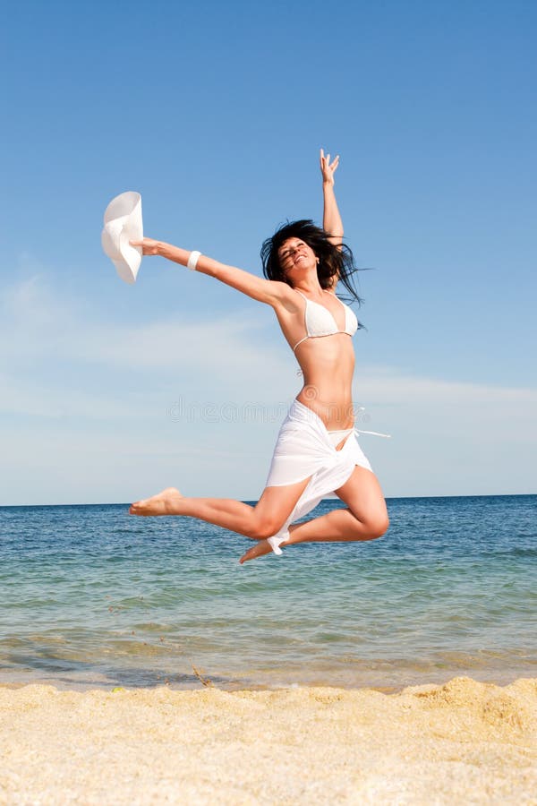 Happy woman jumping in the beach