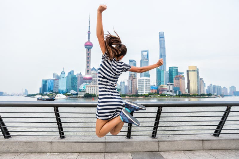 Happy woman jumping of success in city