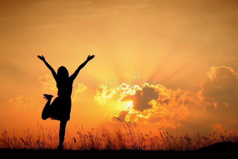 Happy woman jumping and sunset silhouette