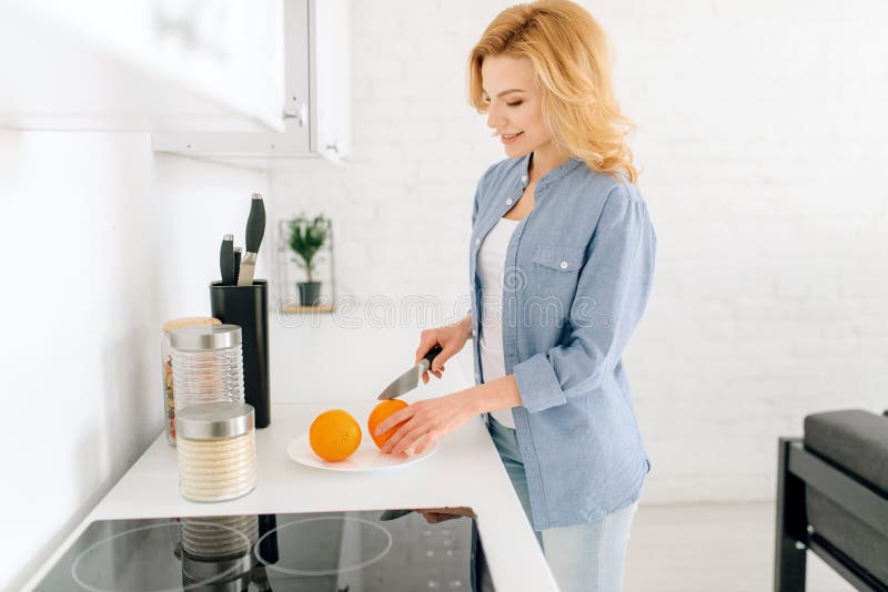 Woman preparing oranges, breakfast on the kitchen royalty free stock photography Woman preparing oranges, breakfast on the kitchen royalty free stock photography