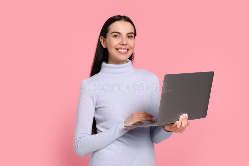 Happy woman with laptop on pink background stock photos