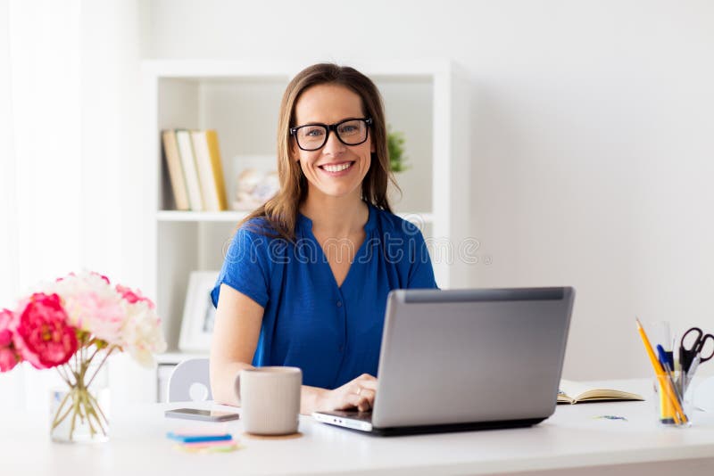 Happy woman with laptop working at home or office royalty free stock photography
