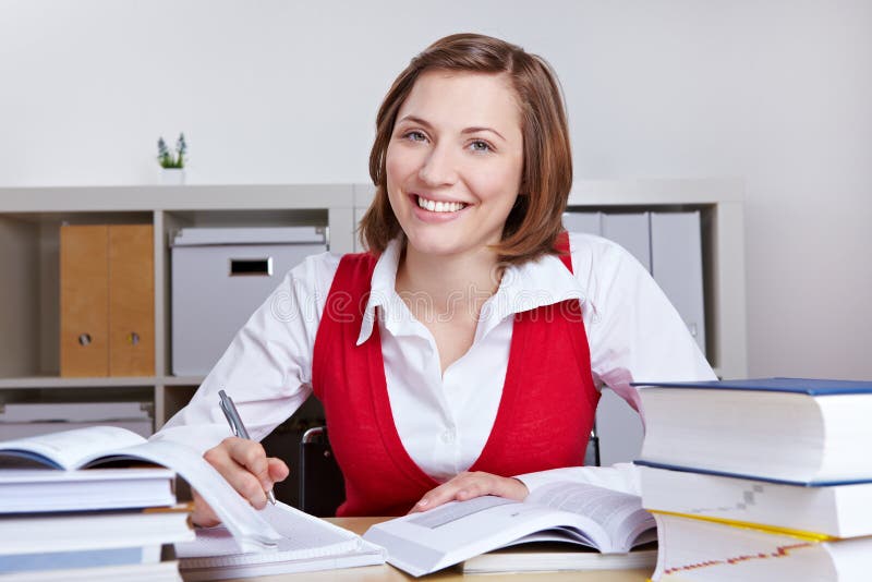 Happy woman learning at her desk royalty free stock image