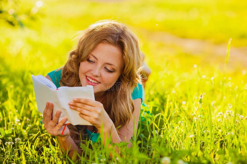 Happy woman sitting reading book outdoors. Happy woman sitting reading book outdoors