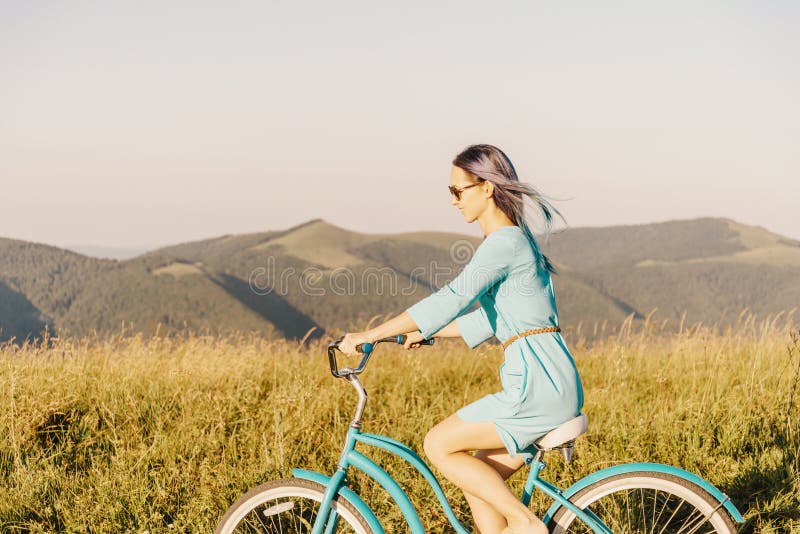 Happy woman riding bicycle in front of mountain ridge. royalty free stock images Happy woman riding bicycle in front of mountain ridge. royalty free stock images