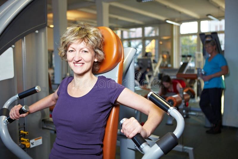 Happy woman on rowing machine royalty free stock image